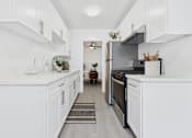 Thumbnail 1 of 37 - A kitchen with white cabinets and appliances.