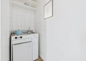 Thumbnail 4 of 12 - A white kitchen with a dishwasher and a stove top.
