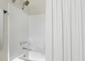 Thumbnail 17 of 83 - a white bathroom with a shower curtain and a sink
