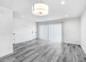 Thumbnail 86 of 102 - an empty living room with white walls and wood flooring