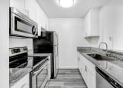Thumbnail 16 of 102 - an all white kitchen with stainless steel appliances and marble counter tops