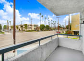 Thumbnail 22 of 102 - a balcony with a view of a street and palm trees