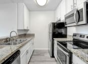 Thumbnail 17 of 102 - a kitchen with granite counter tops and stainless steel appliances