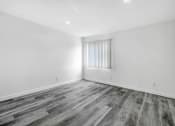 Thumbnail 89 of 102 - an empty living room with white walls and wood flooring