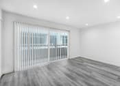 Thumbnail 95 of 102 - an empty living room with a white wall and a sliding glass door
