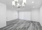 Thumbnail 96 of 102 - an empty living room with white walls and wood floors and a chandelier