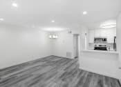 Thumbnail 91 of 102 - an empty living room and kitchen with white walls and wood flooring