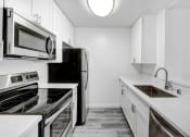 Thumbnail 18 of 102 - an all white kitchen with stainless steel appliances and white cabinets