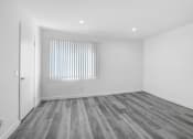 Thumbnail 100 of 102 - a bedroom with white walls and wood flooring and a window