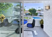Thumbnail 10 of 118 - A patio with a table and chairs overlooking a pool.