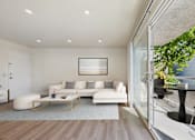 Thumbnail 12 of 118 - A modern living room with a white sofa and a glass table.
