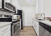 Thumbnail 15 of 118 - A kitchen with black and white appliances and wooden floors.