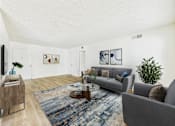 Thumbnail 2 of 70 - A living room with a grey couch, a wooden coffee table, and a blue rug.