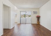 Thumbnail 4 of 61 - A white room with a wooden floor and a white door.