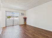 Thumbnail 6 of 61 - A room with a sliding glass door leading to a balcony.