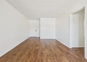 Thumbnail 14 of 61 - A room with wooden floors and white walls.