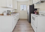Thumbnail 1 of 61 - A kitchen with white appliances and wooden floors.