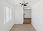 Thumbnail 9 of 61 - A room with a ceiling fan and a doorway leading to another room.