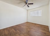 Thumbnail 12 of 61 - Empty room with wooden floor and ceiling fan.