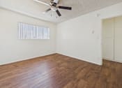 Thumbnail 13 of 61 - A room with a ceiling fan and wooden flooring.