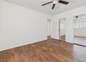 Thumbnail 8 of 61 - A room with wooden floors and a ceiling fan.