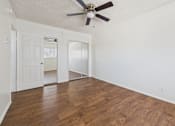 Thumbnail 10 of 61 - A room with a ceiling fan and wooden flooring.