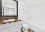 Thumbnail 9 of 35 - A white toilet sits next to a sink in a bathroom.
