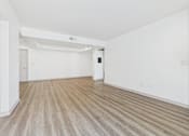 Thumbnail 5 of 35 - A room with wooden flooring and white walls.