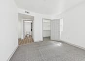 Thumbnail 6 of 35 - A large empty room with a carpeted floor and white walls.