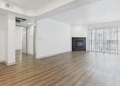 Thumbnail 4 of 35 - A spacious room with wooden flooring and white walls.