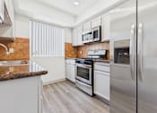 Thumbnail 1 of 35 - A modern kitchen with stainless steel appliances and white cabinets.