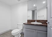 Thumbnail 6 of 24 - A white toilet sits next to a sink in a bathroom.