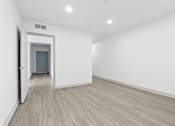 Thumbnail 8 of 24 - A room with a wooden floor and white walls.