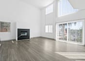 Thumbnail 2 of 24 - A living room with a fireplace and a television.