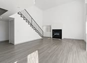 Thumbnail 13 of 24 - A room with a staircase and a fireplace.