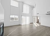 Thumbnail 14 of 24 - A spacious room with wooden floors and white walls.