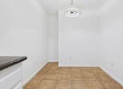 Thumbnail 3 of 15 - A room with a brown tile floor and white walls.