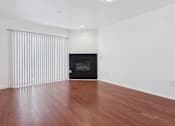 Thumbnail 5 of 15 - A room with a fireplace and wooden floors.