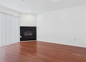 Thumbnail 4 of 15 - A room with a fireplace and wooden floors.