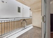 Thumbnail 7 of 15 - A balcony with a metal railing and a white door.