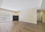 Thumbnail 18 of 30 - A spacious living room with a fireplace and sliding glass doors.