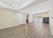 Thumbnail 21 of 30 - A spacious living room with wood flooring and a fireplace.