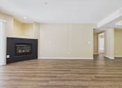 Thumbnail 19 of 30 - A living room with a fireplace and wood flooring.