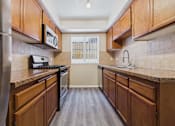 Thumbnail 16 of 30 - A kitchen with wooden cabinets and a stainless steel refrigerator.
