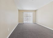 Thumbnail 27 of 30 - A room with a carpeted floor and a white door.
