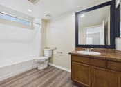 Thumbnail 30 of 30 - A bathroom with a white toilet and a white bathtub.