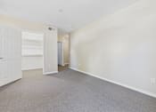 Thumbnail 25 of 30 - A room with a white door and carpeted floor.