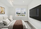 Thumbnail 6 of 13 - A bedroom with a large bed and a flat screen TV mounted on the wall.