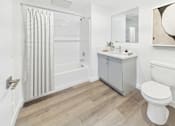 Thumbnail 7 of 13 - A white toilet sits next to a sink in a bathroom.