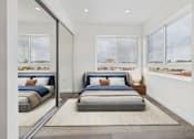Thumbnail 12 of 13 - A bedroom with a large bed and a view of the city.